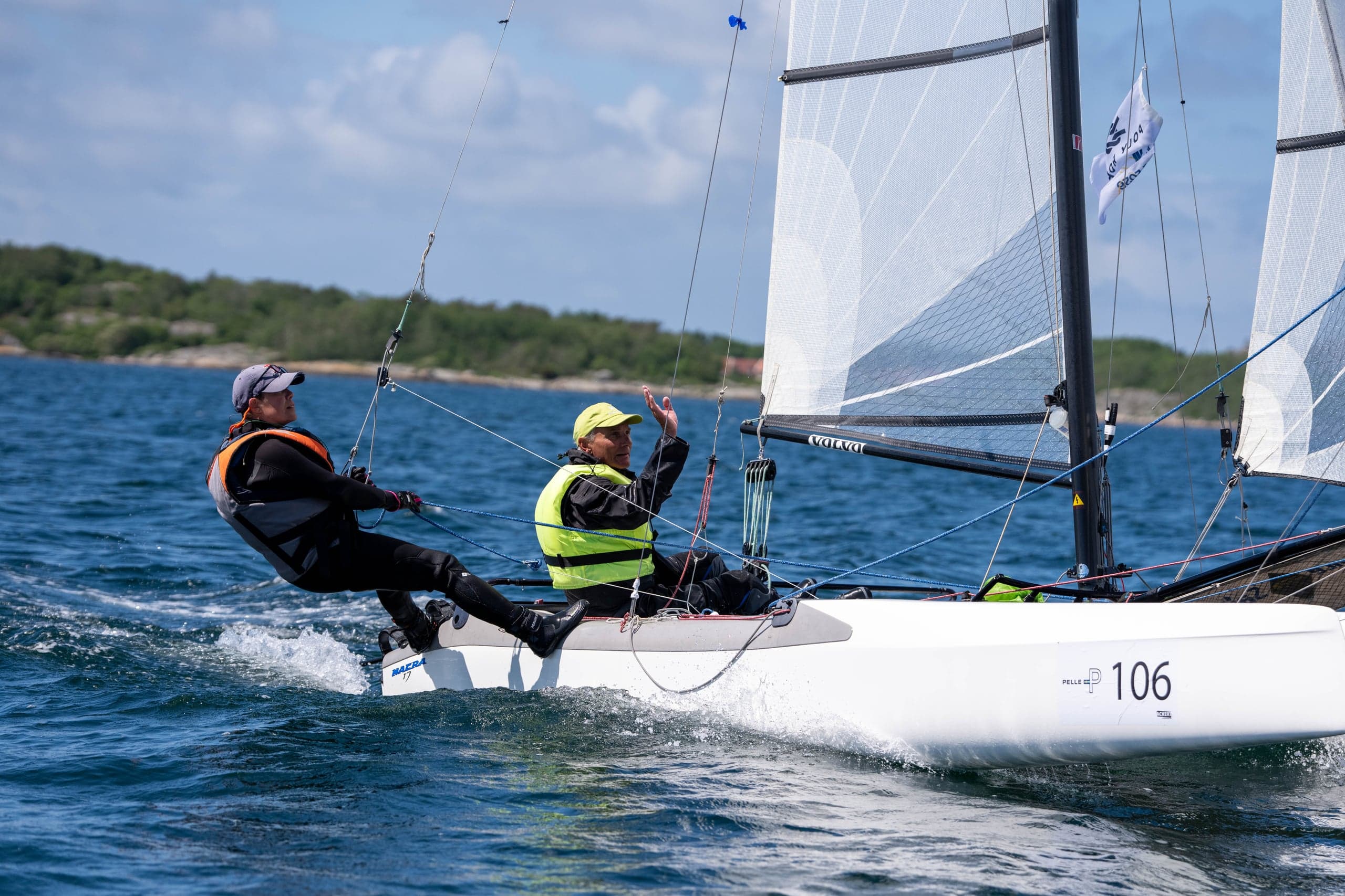 Nacra-katamaran i fart med besättningen ute på trapets